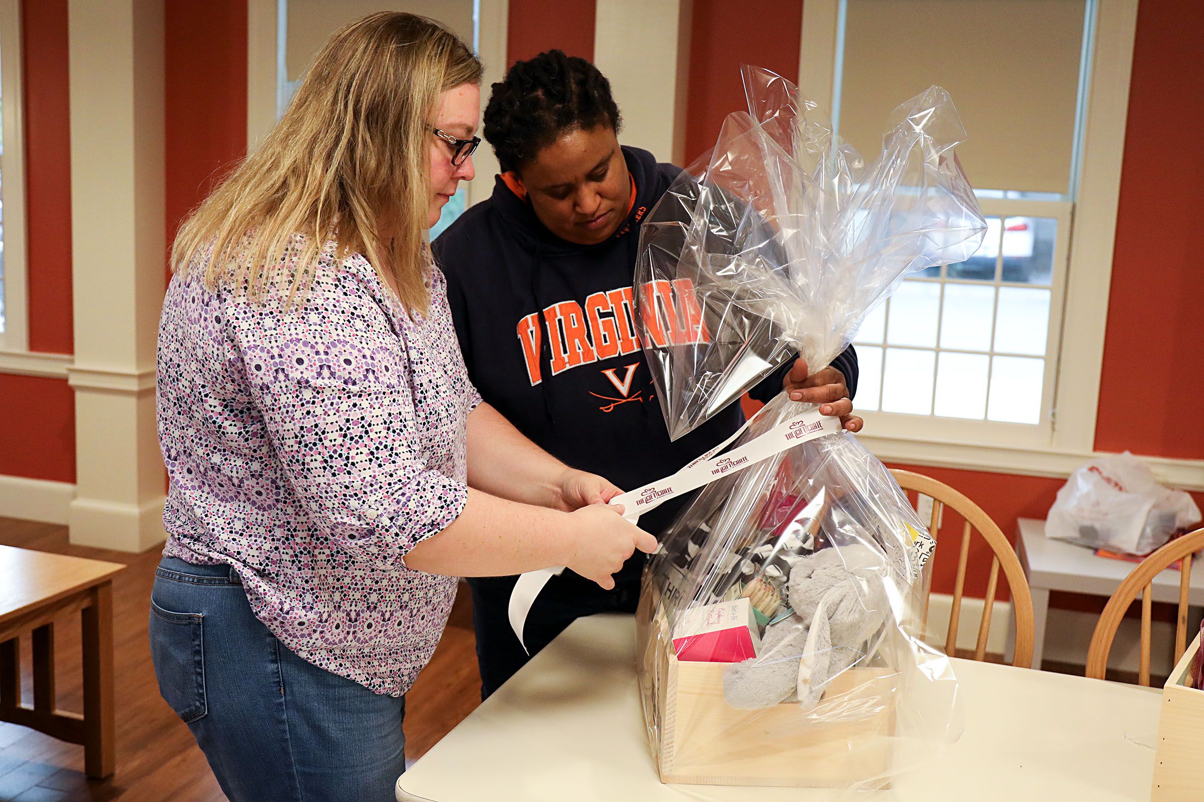 Jen Jones, left, of Hanover, N.H., ties a bow on a Gift Crate, with help from her wife, Dia Draper, also of Hanover, on Monday, Oct. 23, 2017, in the common area of the Triangle House on Dartmouth College campus in Hanover, N.H. The couple works on the business together sending care packages to cancer survivors. (Valley News - Charles Hatcher) Copyright Valley News. May not be reprinted or used online without permission. Send requests to permission@vnews.com