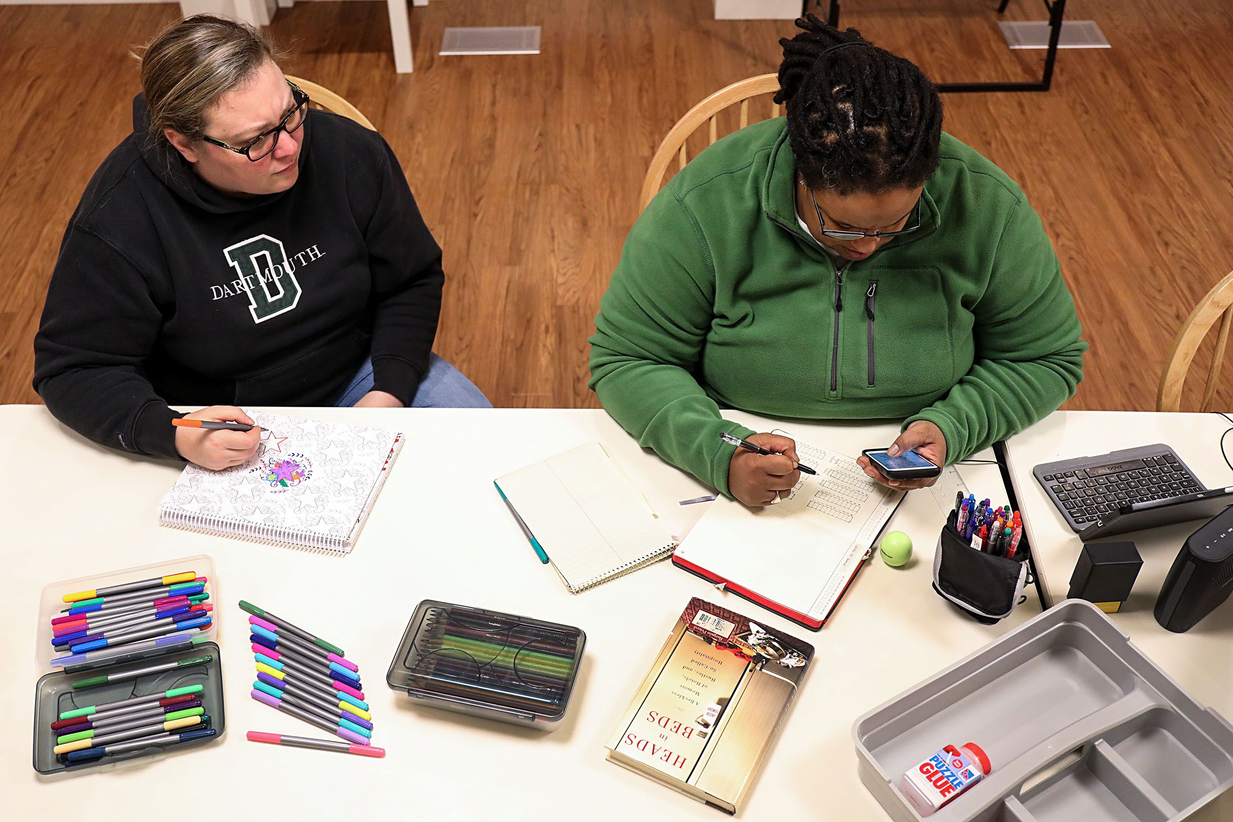 Jen Jones, left, of Hanover, N.H., draws in a coloring book as her wife, Dia Draper, also of Hanover, works on a bullet journal on Monday, Oct. 23, 2017, in the common area at the Triangle House on the Dartmouth College campus in Hanover, N.H. The couple live at the Triangle House as live-in advisors for LGBTQIA+ students living on campus. (Valley News - Charles Hatcher) Copyright Valley News. May not be reprinted or used online without permission. Send requests to permission@vnews.com