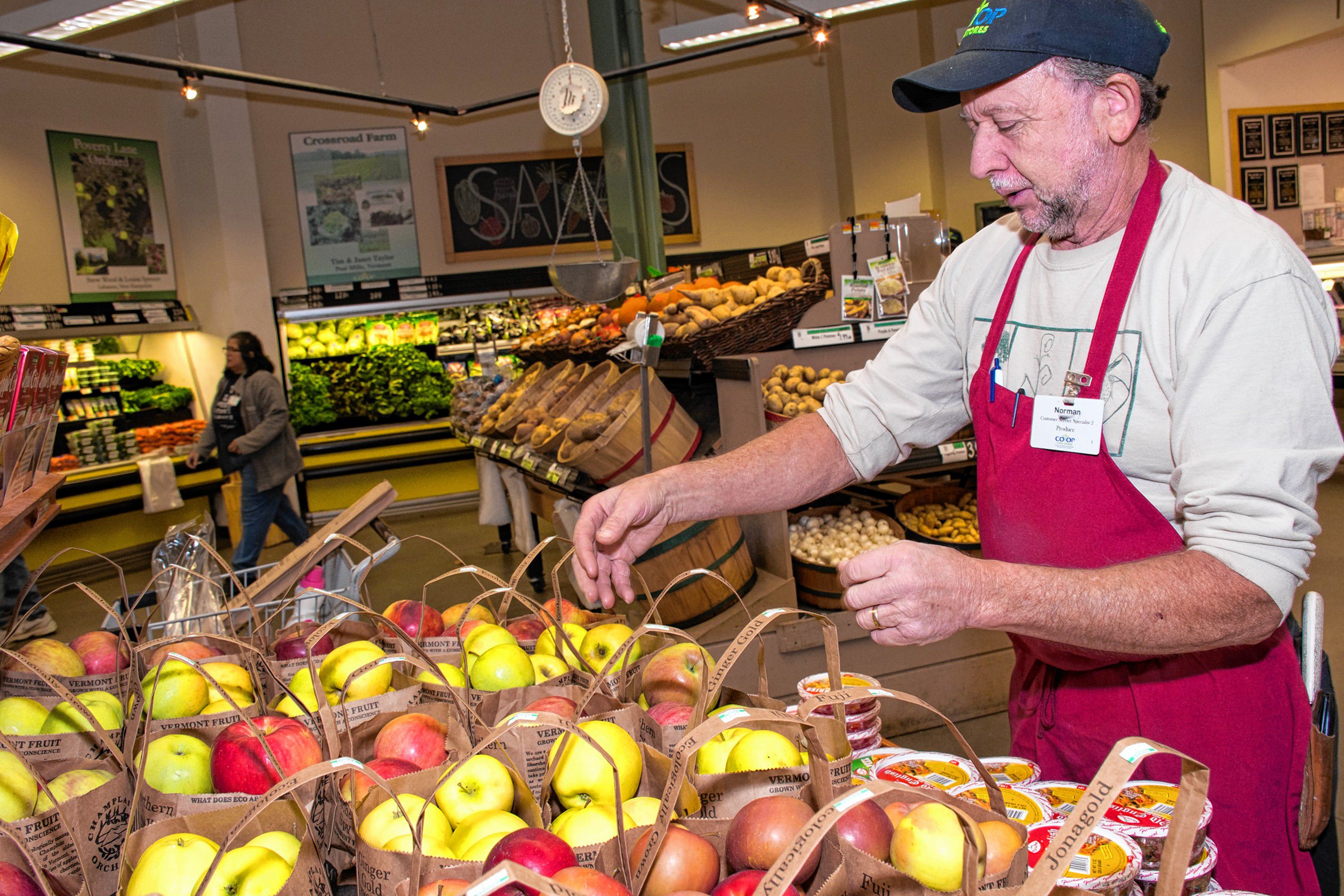 Norman Porter from White River Junction has been with the Co-Op for 10 years. He watches consumers and is there to answer questions about the fruits and vegetables the Co-Op carries. He even makes suggestions on packing to suppliers, like putting the names on apples on the handles so consumers can easily see what variety is in the bag. Nancy Nutile-McMenemy photograph.