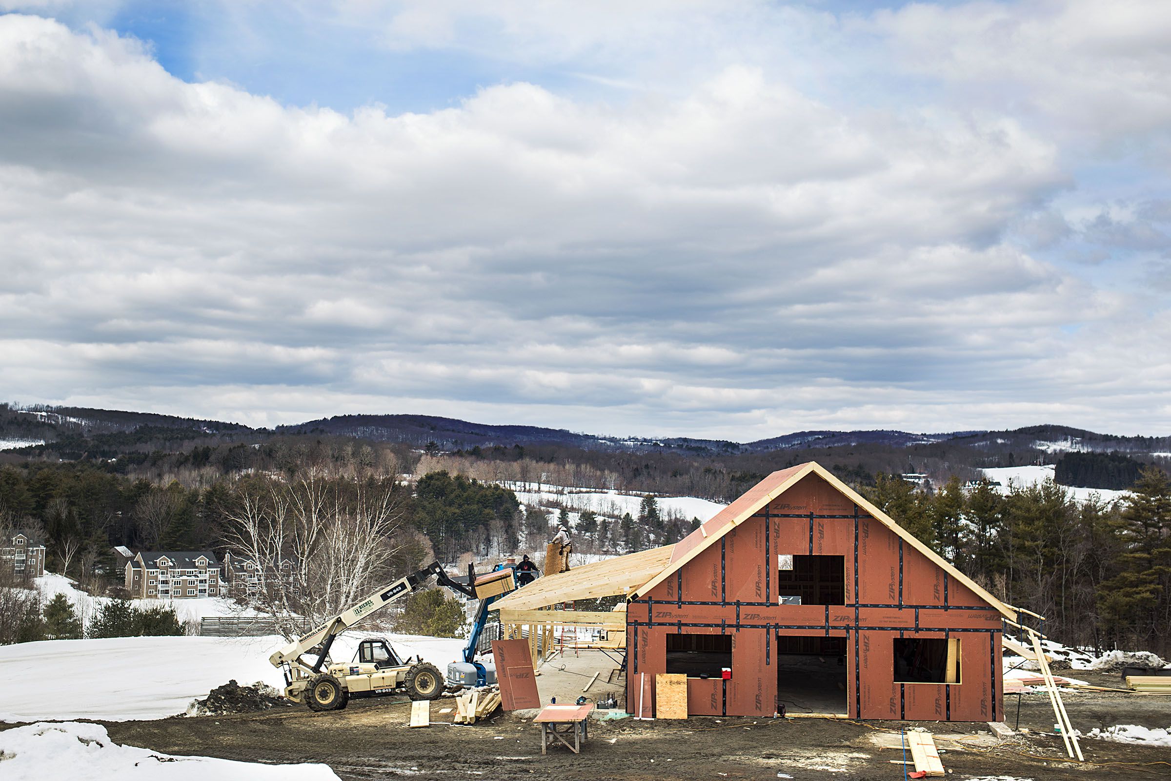 A construction crew works to finish the structure of a building on the foundation of the base lodge of the former Ascutney Mountain Resort in West Windsor, Vt., on March 23, 2018. Ascutney Outdoors member Glenn Seward said the project aims to be completed by the end of July 2018. "This has been a big part of the community," Seward said. "To see it continue on is very exciting." (Valley News - Carly Geraci) Copyright Valley News. May not be reprinted or used online without permission. Send requests to permission@vnews.com.