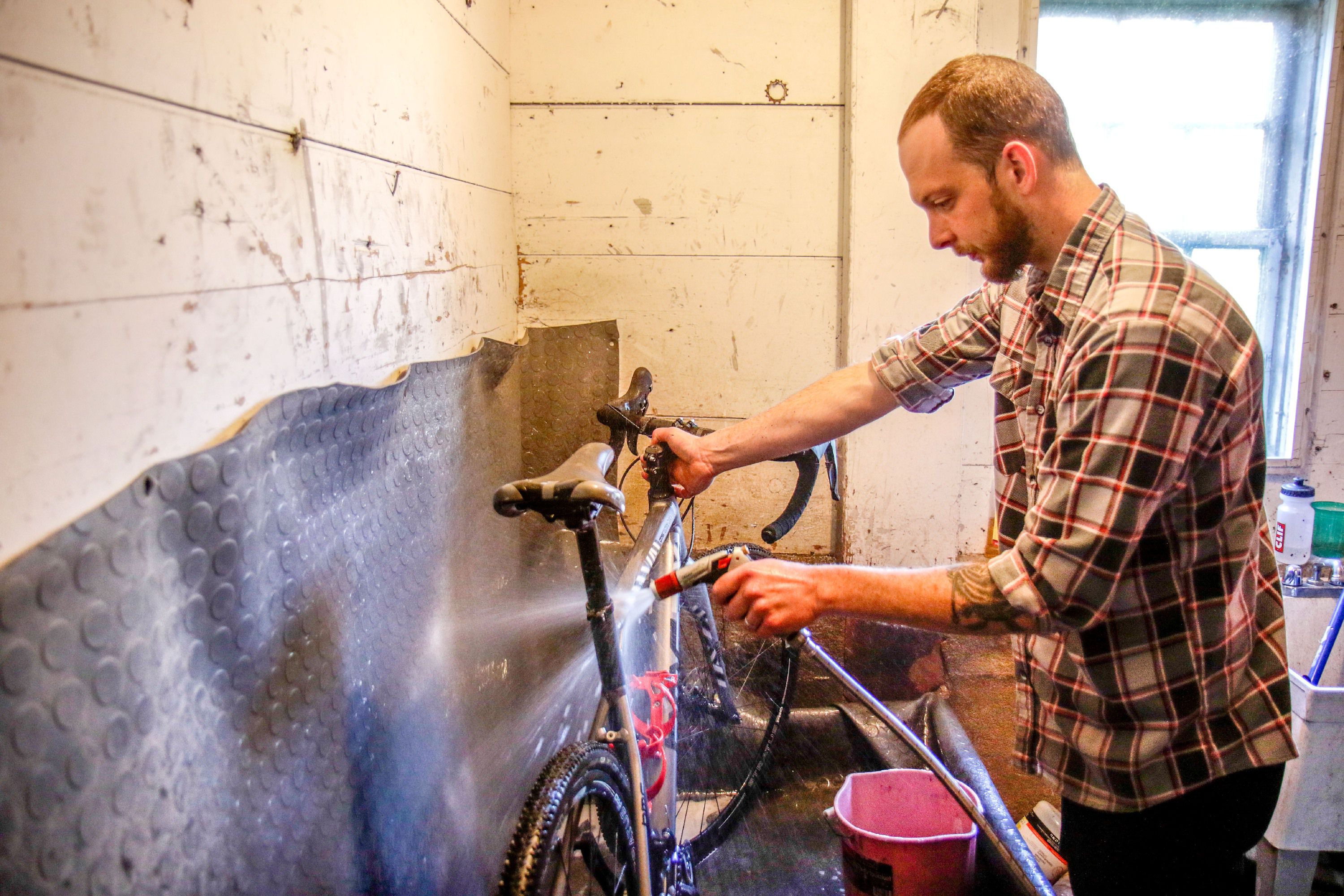 Robbie Boody, of Sharon, Vt., washes off a bike in Drummond Cycles in Enfield, N.H., on Wednesday, June 5, 2018. Each bike that comes into the shop for a tune up gets a standard washing treatment. (Valley News - August Frank) Copyright Valley News. May not be reprinted or used online without permission. Send requests to permission@vnews.com.