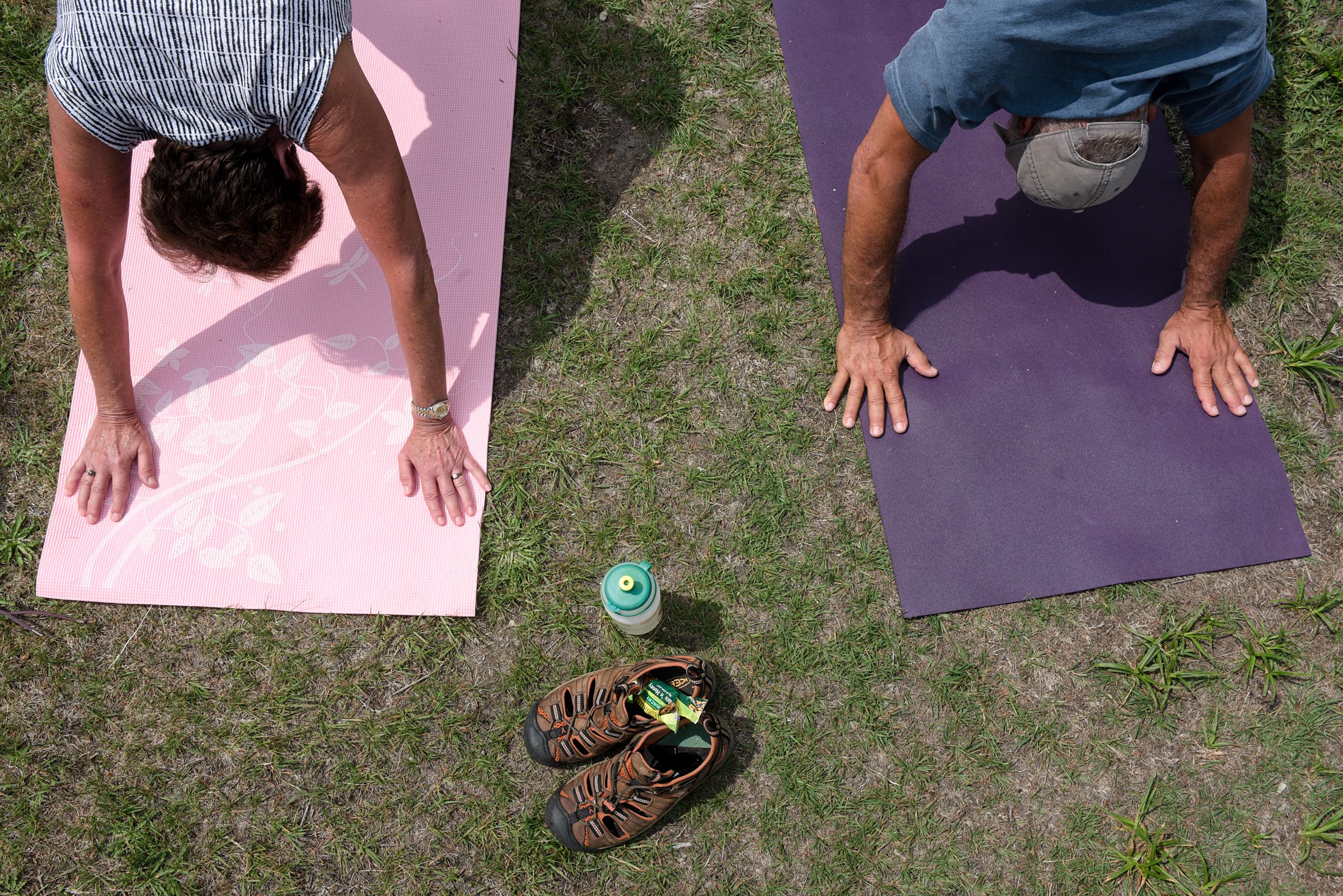 Linda Sacco, left, and Arthur Sacco, of Newbury, hold their downward dog position during yoga at the top of Mount Sunapee in Newbury, N.H., Wednesday, July 11, 2018. (Valley News - James M. Patterson) Copyright Valley News. May not be reprinted or used online without permission. Send requests to permission@vnews.com.