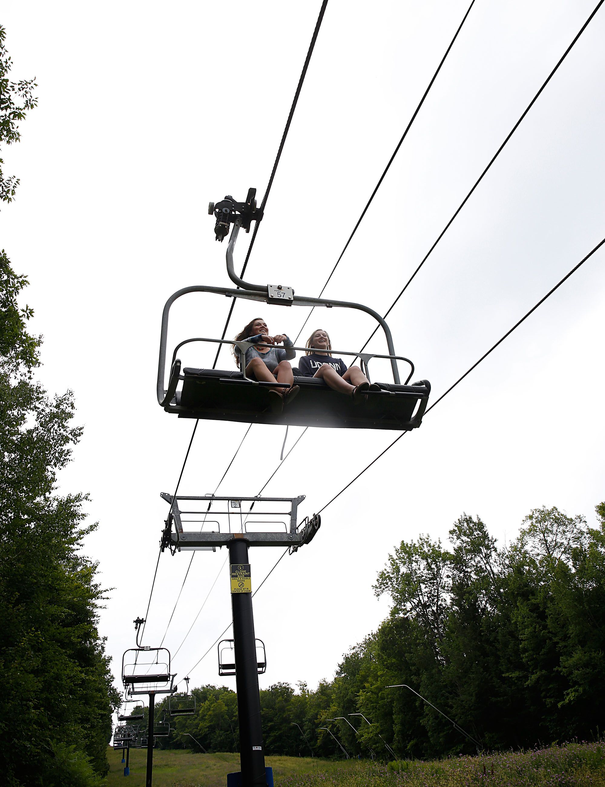 After spending time at the summit with their friends, Ali Sailer, of Warner, N.H., left, and Taylor Ludl, of Ridgefield, Conn., ride the chairlift down the mountain at the Mount Sunapee Resort in Sunapee, N.H., on July 14, 2018. Sailer said she spends a lot of time at the resort year round. "This is home," she said. (Valley News - Geoff Hansen) Copyright Valley News. May not be reprinted or used online without permission. Send requests to permission@vnews.com.