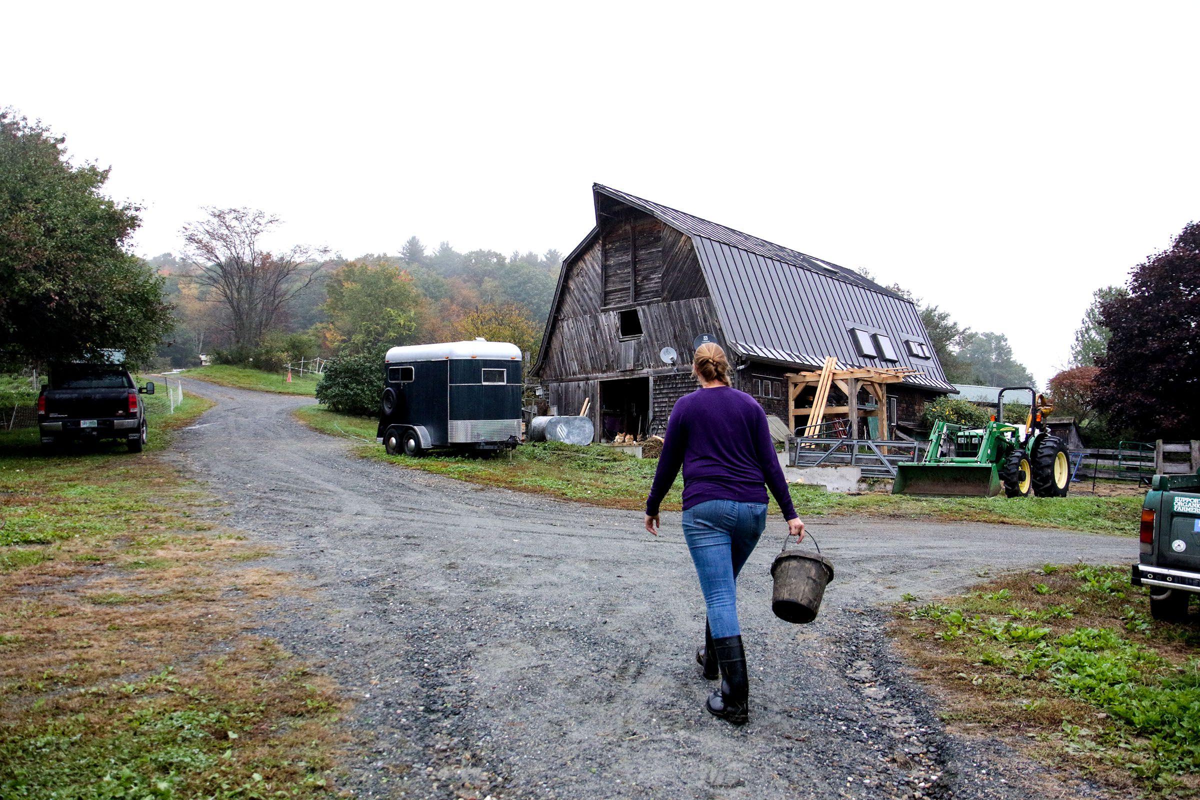 Heather Gallagher makes her way back to the barn upon completion of her morning chores at Many Summers Farm, in Cornish, N.H., on Monday, Oct. 8, 2018. (Valley News - August Frank) Copyright Valley News. May not be reprinted or used online without permission. Send requests to permission@vnews.com.