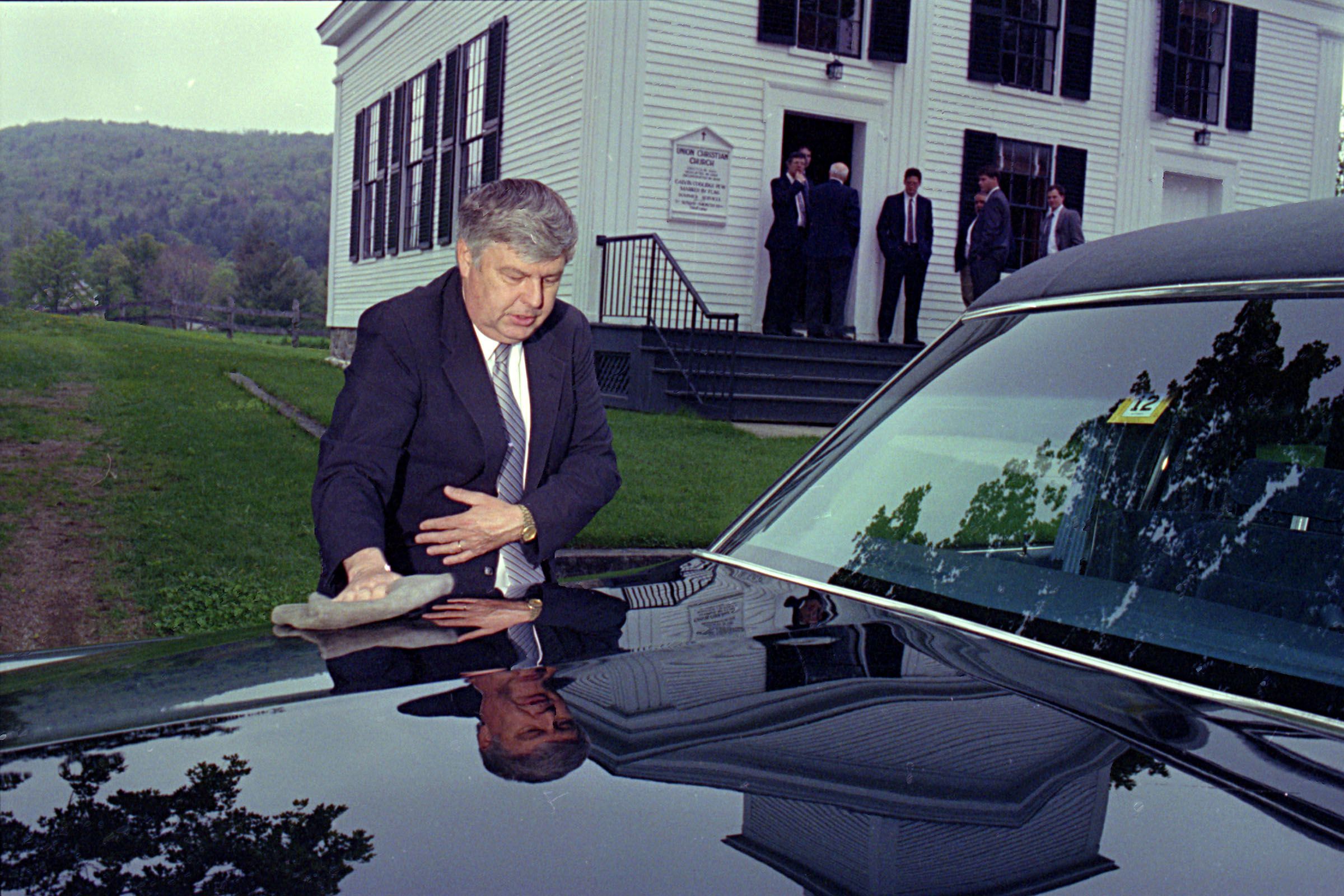 Dwight Camp dusts off the Cadillac hearse at a funeral held at Plymouth Notch, Vt., on May 20, 1993. Camp is amongst four generations who have owned Cabot Funeral Home in Woodstock. The life of a funeral director is not all somber and grim. "We cry with the people, but we laugh with them, too," he said. (Valley News - Medora Hebert) Copyright Valley News. May not be reprinted or used online without permission. Send requests to permission@vnews.com.
