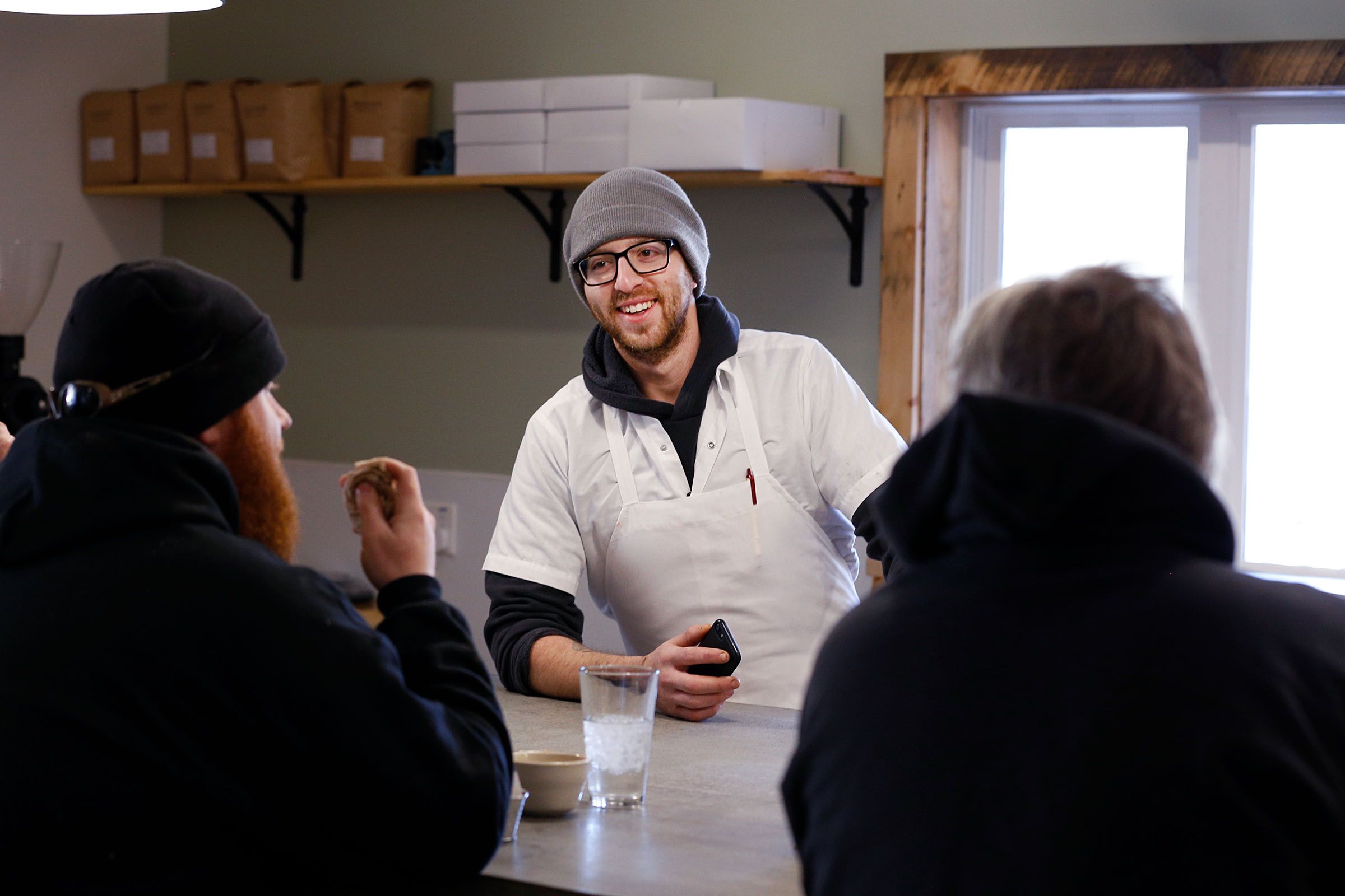 Co-owner Peter Varkonyi talks with Kristian Kurtzhalz, left, and Bob Cerra, both of Brownsville, while they eat lunch at the Brownsville Butcher & Pantry in Brownsville, Vt., on Jan. 17, 2019.  Kurtzhalz said that life without a store in town was a challenge. "This has been a huge convenience for the town," Cerra added. "It's what this town needs."  (Valley News - Joseph Ressler) Copyright Valley News. May not be reprinted or used online without permission. Send requests to permission@vnews.com.