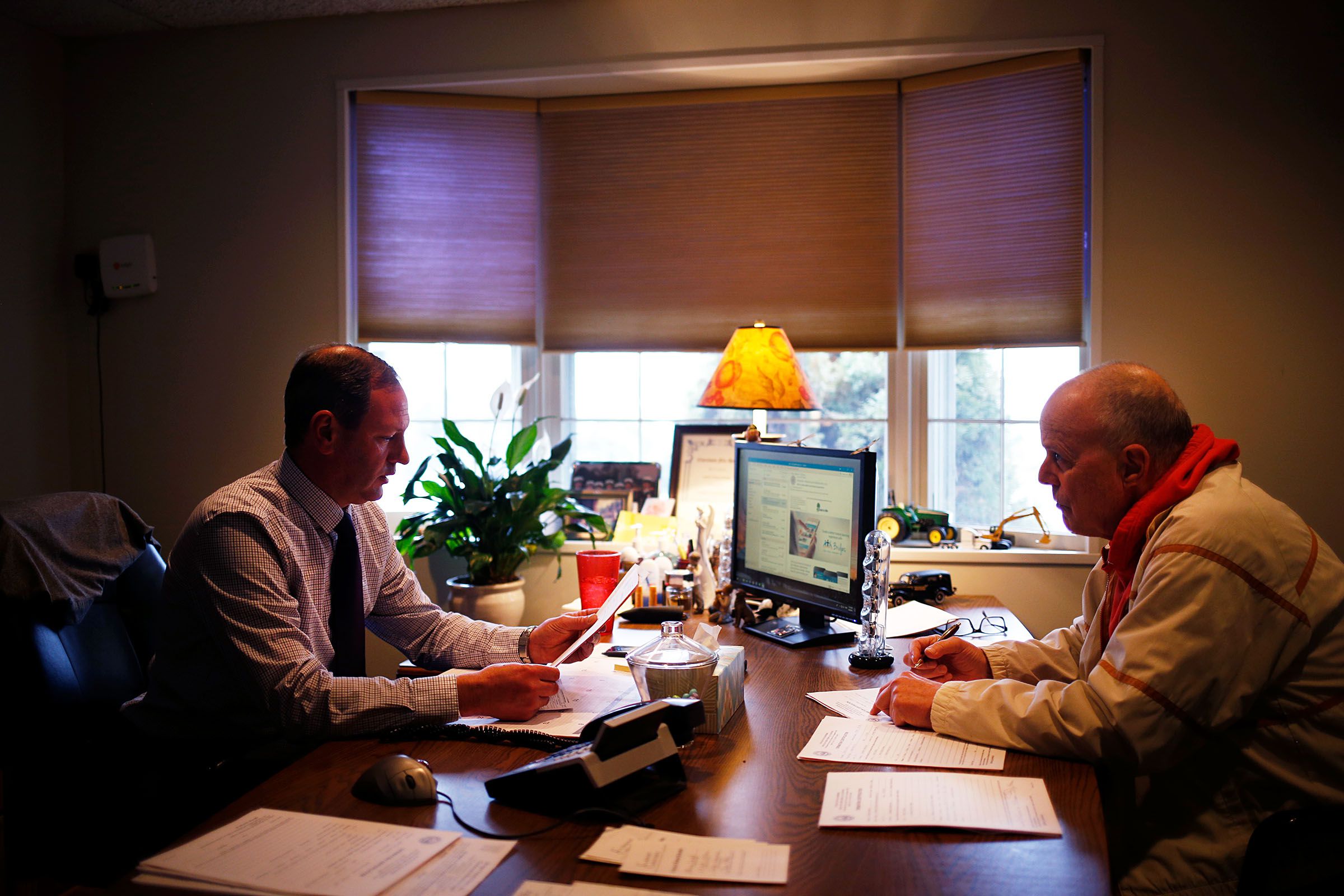 Owner Mike Stringer, left, meets with with New Hampshire Assistant Deputy Medical Examiner Mike Raymond to sign permissions for cremations at Stringer Funeral Home in Claremont, N.H., on Tuesday, April 9, 2019. Every cremation requires approval from a medical examiner. The funeral home now has a crematorium on site to make the process much easier. (Valley News - Joseph Ressler) Copyright Valley News. May not be reprinted or used online without permission. Send requests to permission@vnews.com.
