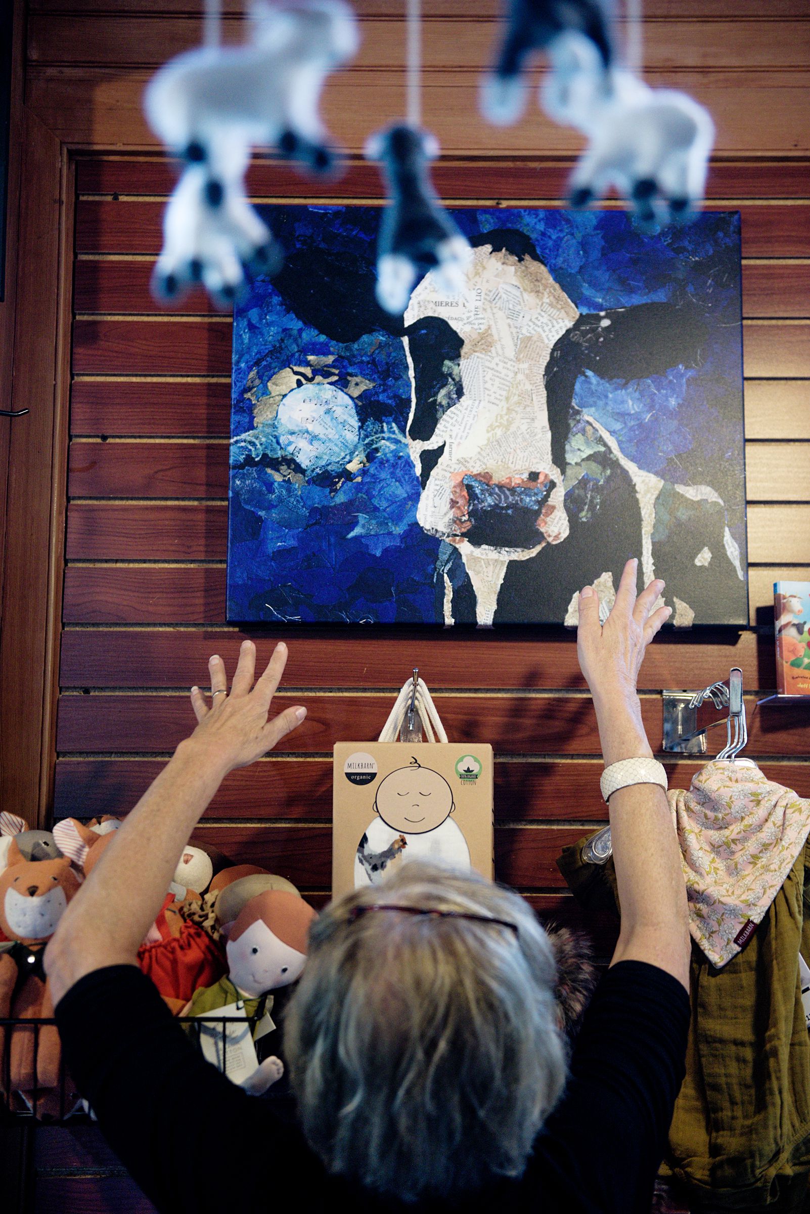 Liz Joyce straightens a piece of art on the wall of her story Country Kids at the Powerhouse mall in West lebanon, N.H., Wednesday, June 26, 2019. (Valley News - James M. Patterson) Copyright Valley News. May not be reprinted or used online without permission. Send requests to permission@vnews.com.