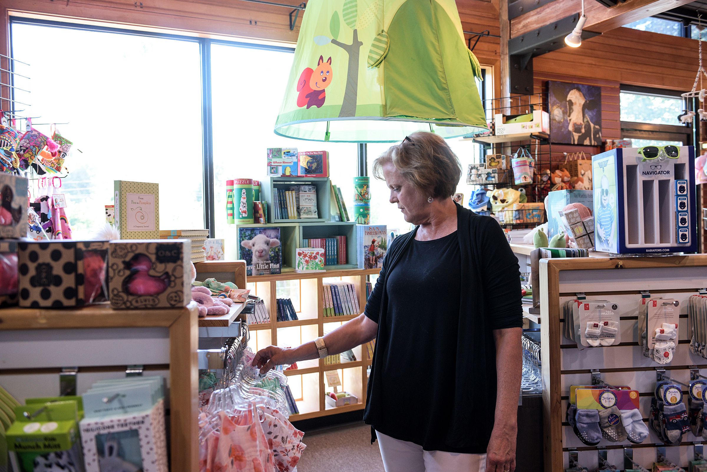 Liz Joyce, of Pomfret, tidies up her merchandise at Country Kids at the Powerhouse Mall in West Lebanon, N.H., after returning to work from a vacation Wednesday, June 26, 2019. Joyce said that she tries to differentiate her store from online retailers by carrying unique products and through a higher level of customer service. (Valley News - James M. Patterson) Copyright Valley News. May not be reprinted or used online without permission. Send requests to permission@vnews.com.