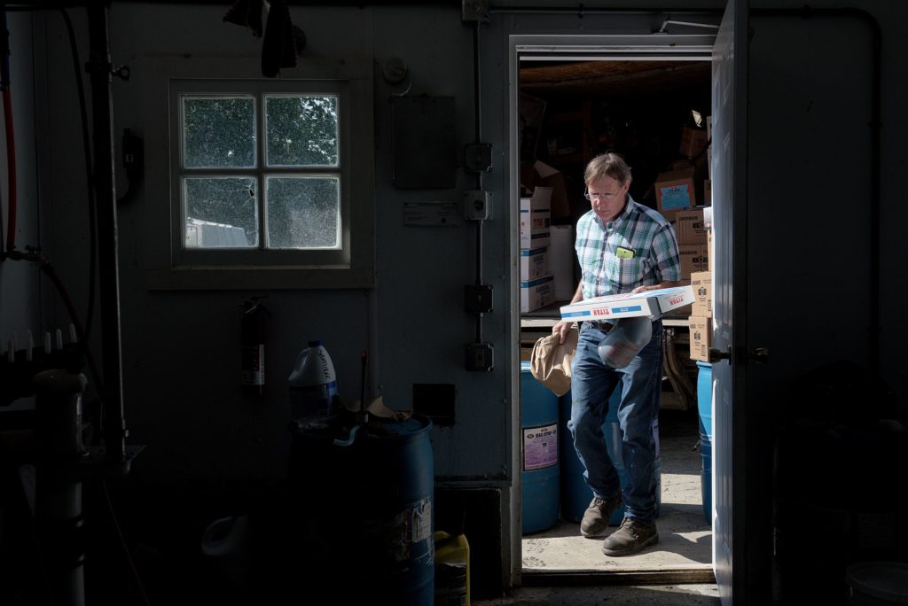 John Kerr, 58, has sold and delivered dairy supplies through Independent Buyers Alliance (IBA) for 30 years and covers a territory that extends from Whitehall, N.Y. through the White River Valley to western New Hampshire and down to Brattleboro. Kerr drops off a load of supplies in the milk house at Liberty Hill Farm in Rochester, Vt., Wednesday, July 3, 2019. (Valley News - James M. Patterson) Copyright Valley News. May not be reprinted or used online without permission. Send requests to permission@vnews.com.