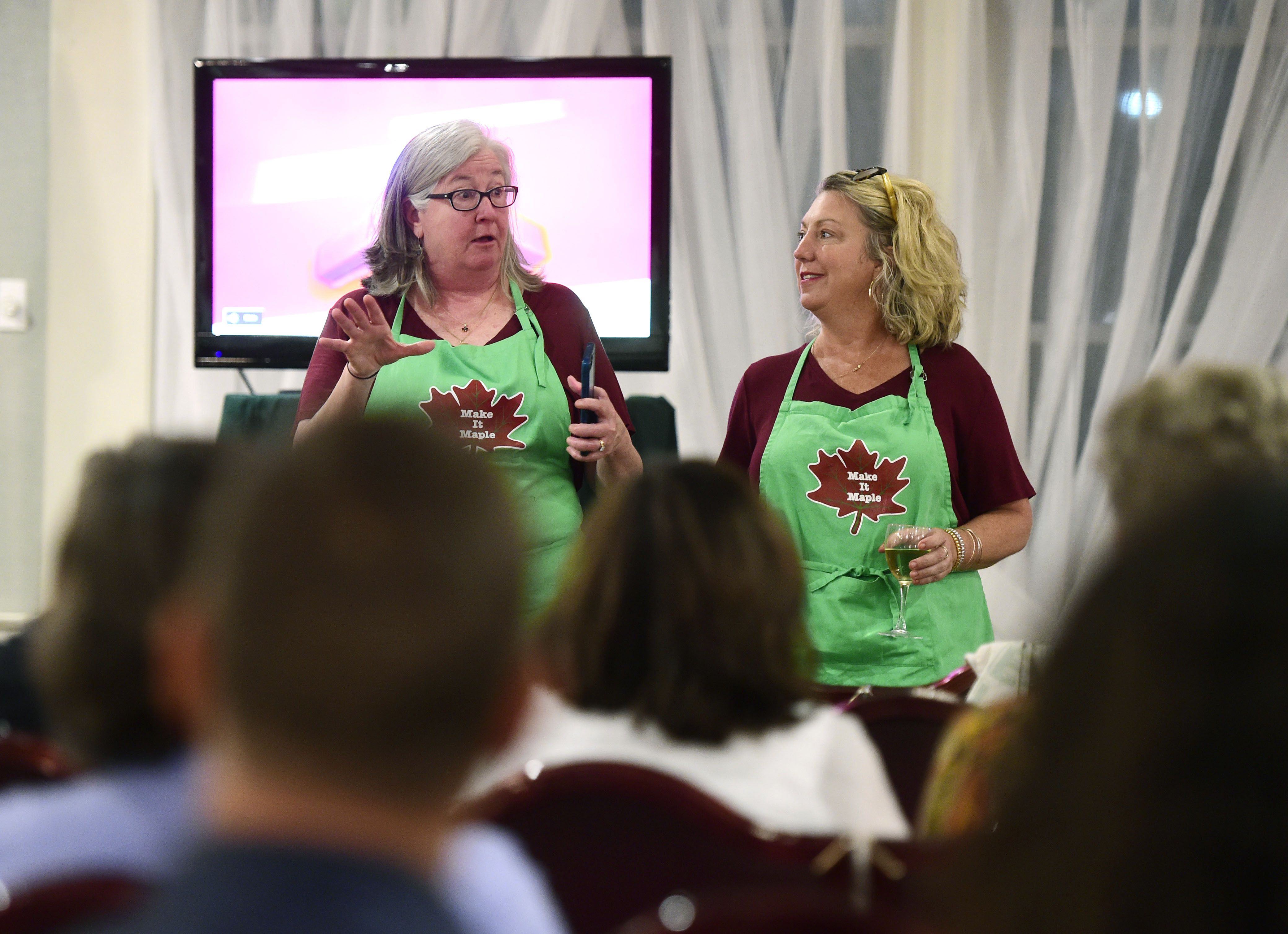 Sue Aldrich, left, and Paulette Fiorentino, both of Montpelier, Vt., explain some of the behind-the-scene details of their time competing on The Great Food Truck Race during a screening party for the opening episode at the Capital Plaza in Montpelier, Vt. on June 9, 2019. The reality program airs on The Food Network and the pair, along with Aldrich's son, Charlie, competed as the Make It Maple team.