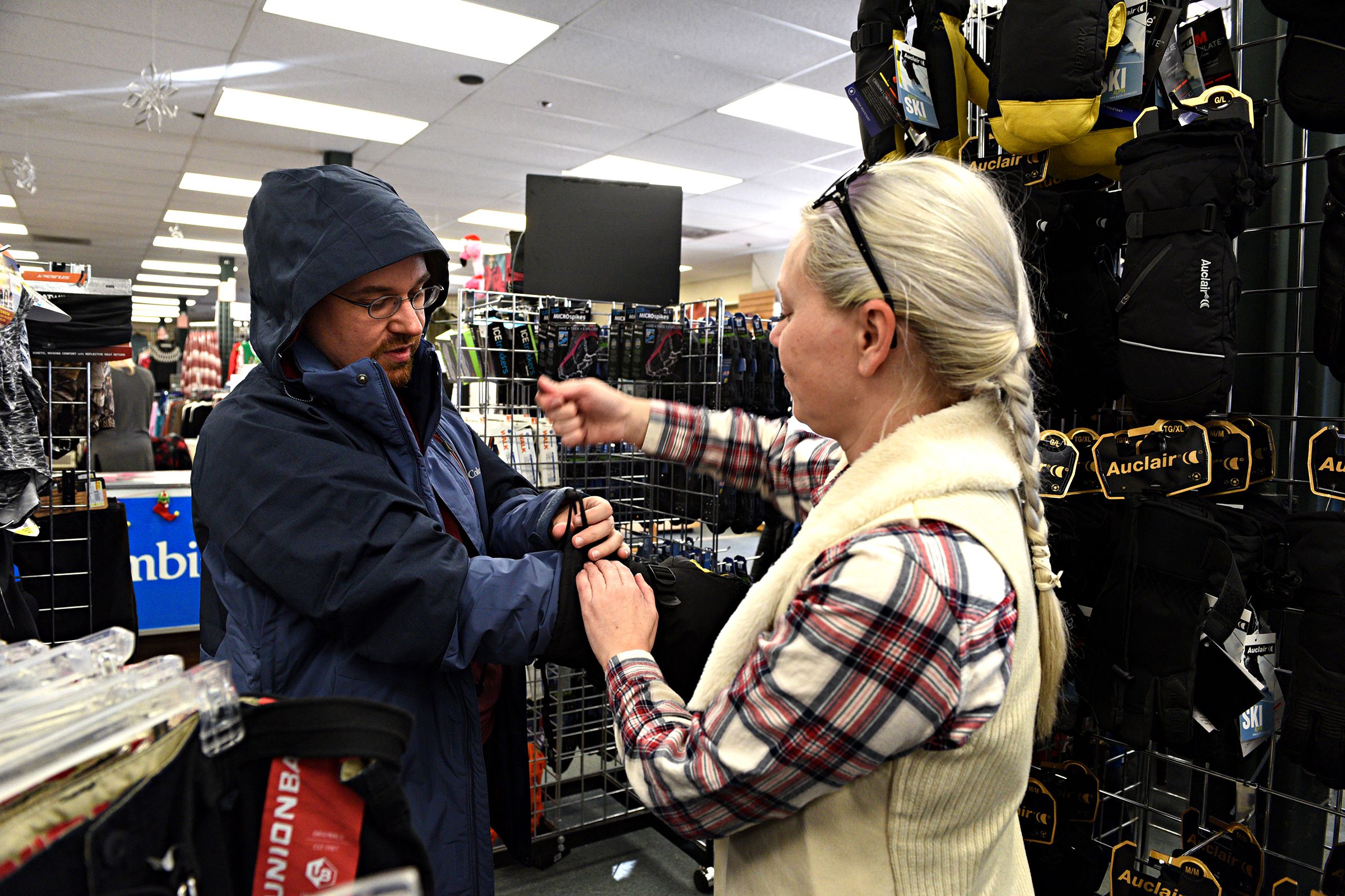 Amber Grantham, of Sunapee, N.H., helps her friend Dustin Springer, of Claremont, N.H., into new ski gear at Hubert's in Lebanon, N.H., on Saturday, Dec. 28, 2019. Grantham is teaching Springer to ski, starting with helping him pick out winter gear. (Valley News - Jennifer Hauck) Copyright Valley News. May not be reprinted or used online without permission. Send requests to permission@vnews.com.