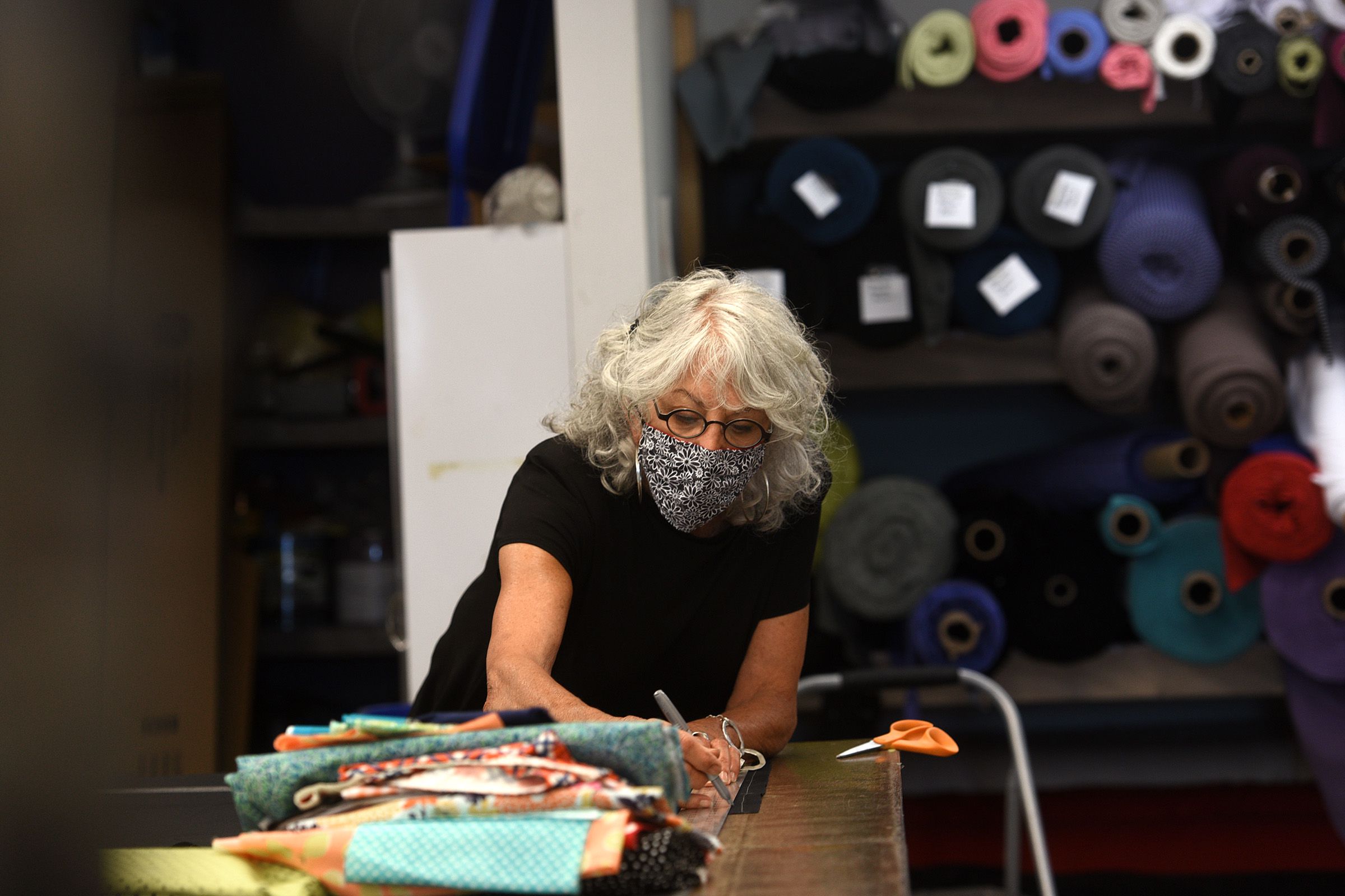 Joan Ecker, co-owner of Fat Hat Clothing Co., cuts material for masks on Wednesday, July 1, 2020, in Quechee, Vt. The company has made 5,000 cloth masks during the COVID-19 pandemic. (Valley News - Jennifer Hauck) Copyright Valley News. May not be reprinted or used online without permission. Send requests to permission@vnews.com.