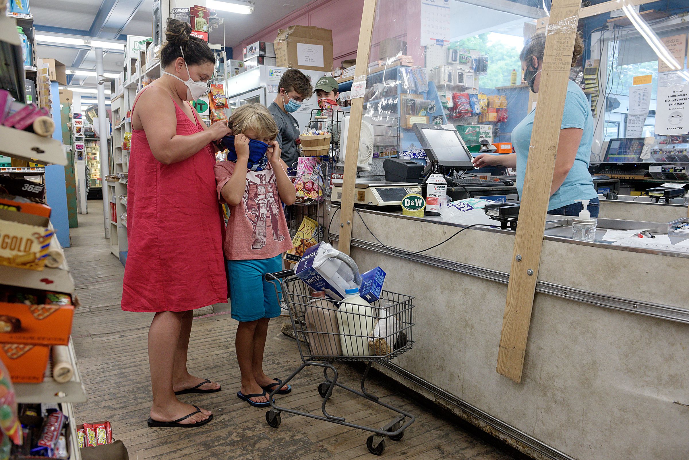 Nichole Rossi, of Norwich, adjusts her son Josh’s mask as they step up to pay for groceries at Dan and Whit’s general store in Norwich, Vt., Thursday, July 9, 2020. (Valley News - James M. Patterson) Copyright Valley News. May not be reprinted or used online without permission. Send requests to permission@vnews.com.