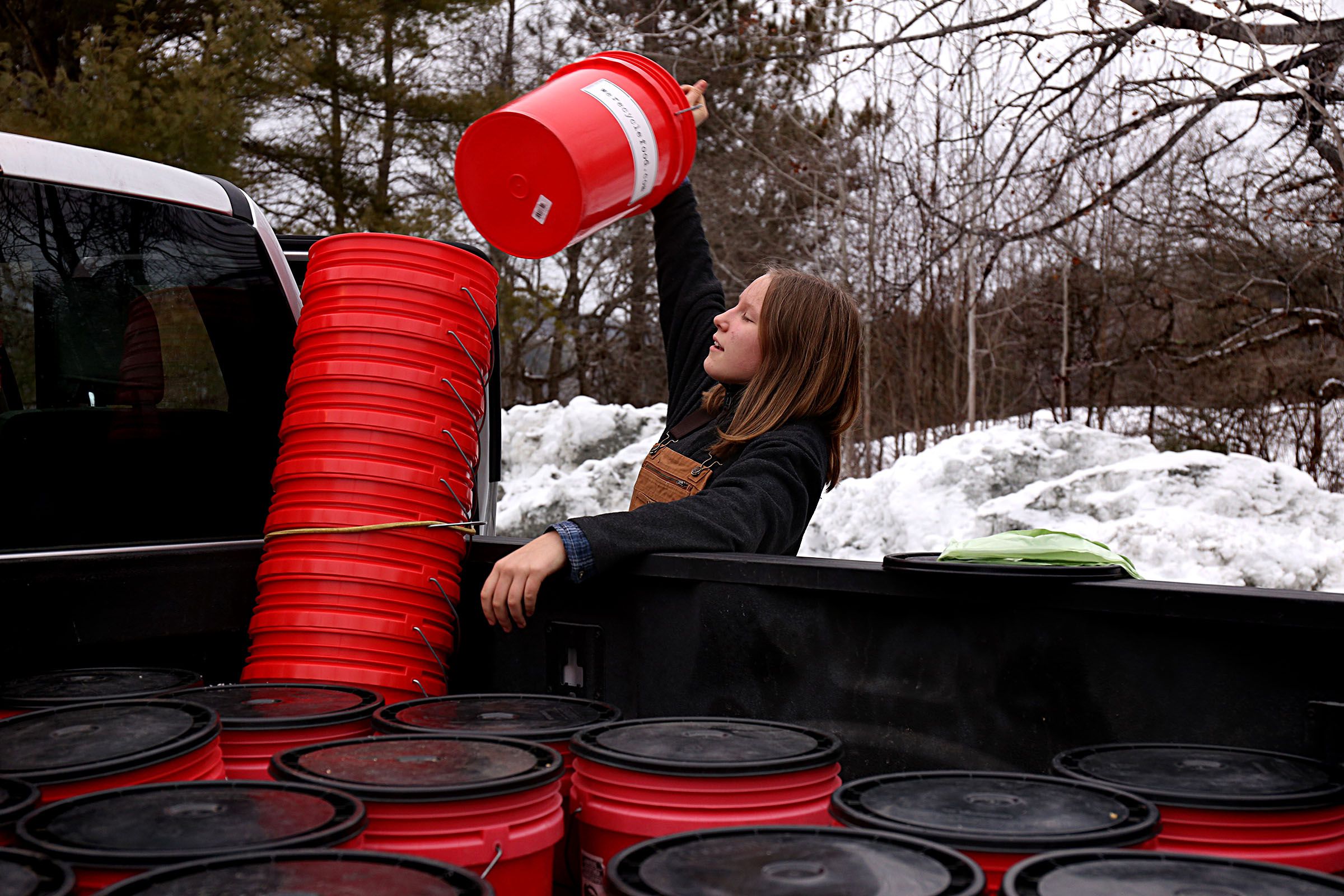 Lydia Dickey, 12, unloads clean compost buckets for customers while helping her father on the route in Woodstock, Vt., on Jan. 14, 2021. Nordic Waste Service's We Recycle Food program offers weekly curbside, drop-off and commercial services for composting and currently has over 200 clients across the Upper Valley. (Valley News - Geoff Hansen) Copyright Valley News. May not be reprinted or used online without permission. Send requests to permission@vnews.com.