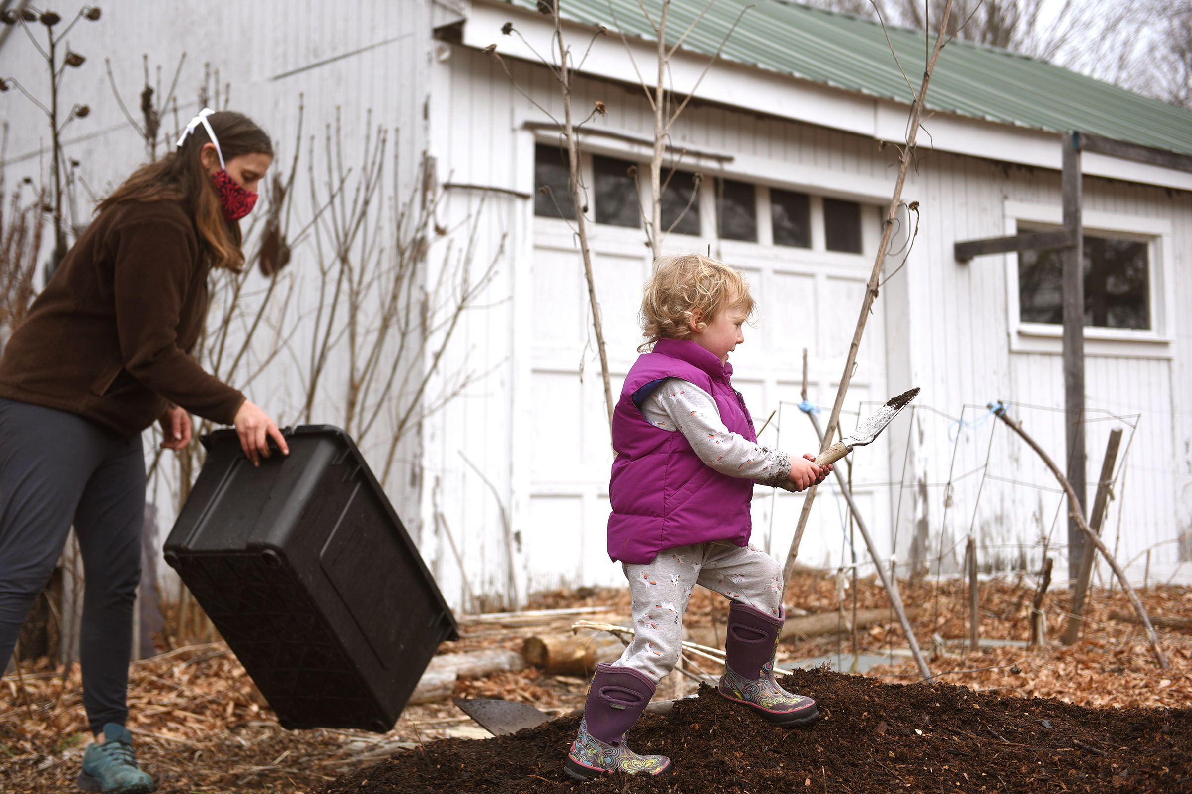 Willow Murphy helps her mother Jen Murphy shift compost at their home in Wilder, Vt., on Thursday, March, 25, 2021. The compost on the ground is about a year old after is was moved through numerous bins. (Valley News - Jennifer Hauck) Copyright Valley News. May not be reprinted or used online without permission. Send requests to permission@vnews.com.