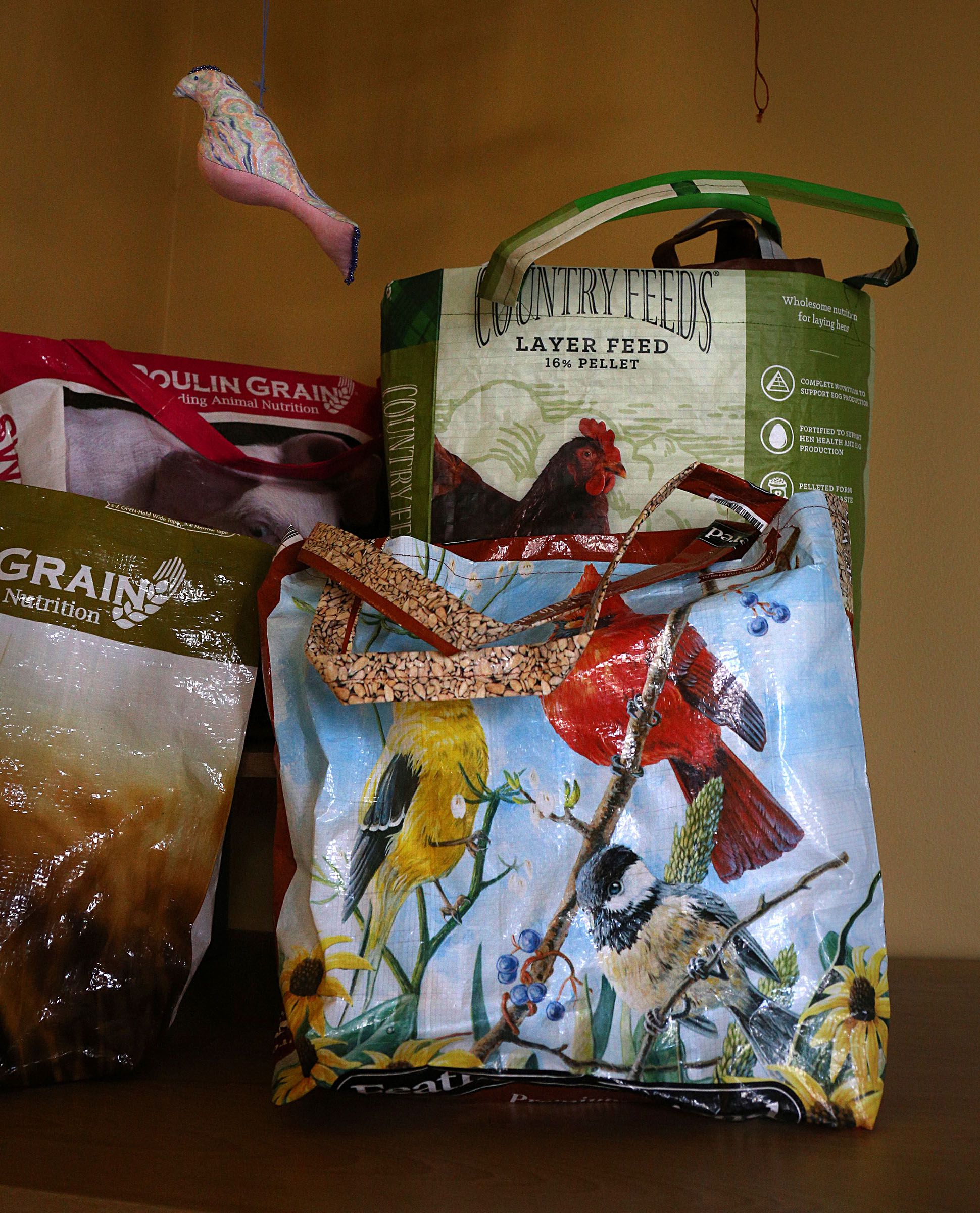 Shopping bags made from 50 lb. grain and birdseed bags are on display at The Family Place's Farm to Bags program in Wilder, Vt., on March 25, 2021. While the COVID-19 pandemic has limited onsite locations where bags and umbrellas made by participants in the Families Learning Together can be sold, they are also for sale on their Etsy site. (Valley News - Geoff Hansen) Copyright Valley News. May not be reprinted or used online without permission. Send requests to permission@vnews.com.