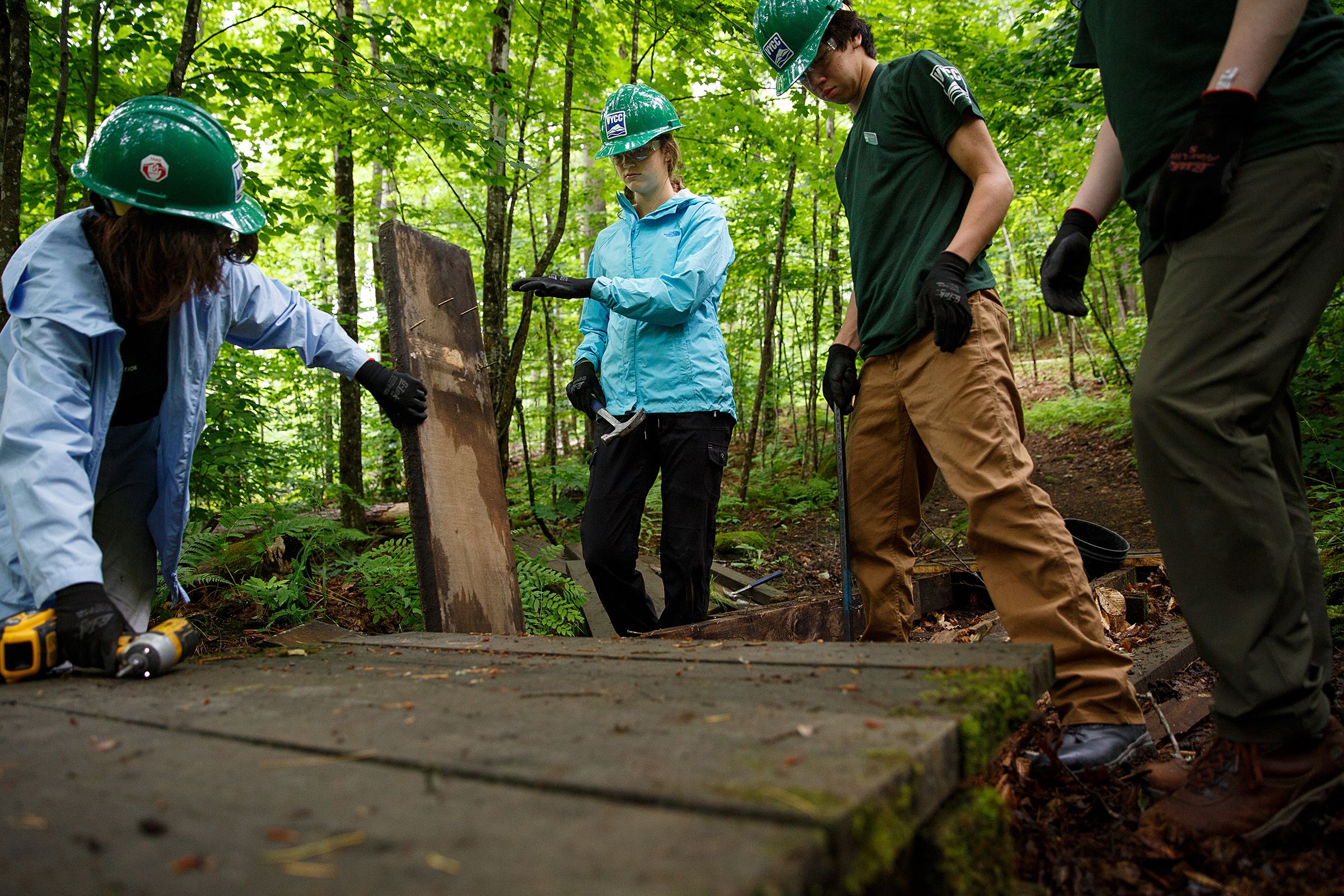Vermont Youth Conservation Corps members, from left, Beatrix Garza, 15, of Woodstock, Vt., Chloe Masillo, 15, of Pittsfield, Vt., Ben Johnsen, 15, of Pomfret, Vt., and Andries Morin, 16, of Pittsfield, Vt., work to replace a footbridge near the Prosper Trail trailhead at Marsh-Billings-Rockefeller National Historic Park in Woodstock, Vt., on Tuesday, June 22, 2021. VYCC hires young people, ages 15-26, to do farm and conservation work throughout the state to help them gain leadership and career skills while engaging with Vermont's natural environment. (Valley News / Report For America - Alex Driehaus) Copyright Valley News. May not be reprinted or used online without permission. Send requests to permission@vnews.com.