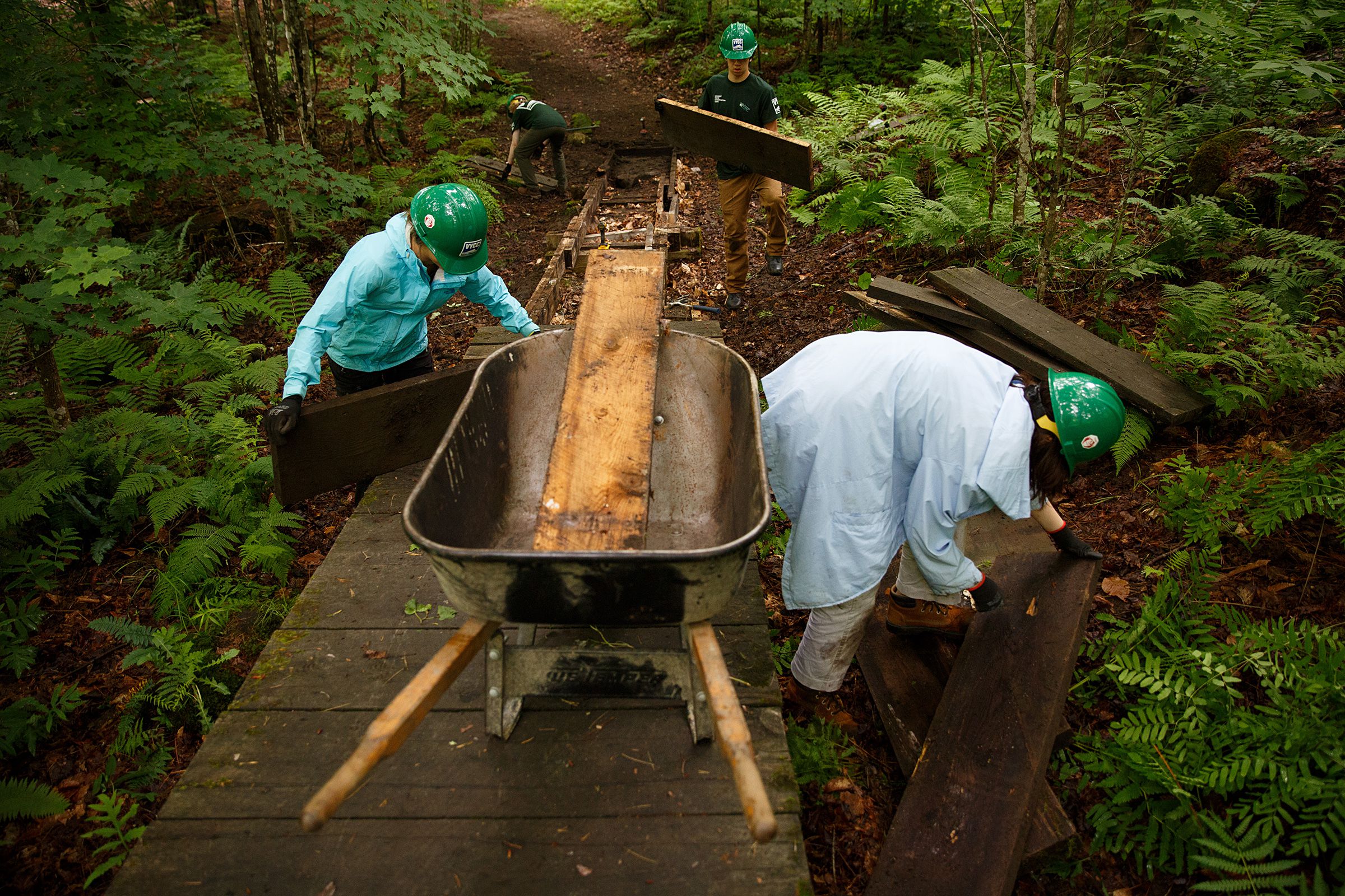 Vermont Youth Conservation Corps members, from left, Chloe Masillo, 15, of Pittsfield, Vt., Andries Morin, 16, of Pittsfield, Vt., Ben Johnsen, 15, of Pomfret, Vt., and  Beatrix Garza, 15, of Woodstock, Vt., work to replace a footbridge near the Prosper Trail trailhead at Marsh-Billings-Rockefeller National Historic Park in Woodstock, Vt., on Tuesday, June 22, 2021. (Valley News / Report For America - Alex Driehaus) Copyright Valley News. May not be reprinted or used online without permission. Send requests to permission@vnews.com.