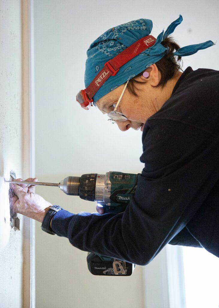Joanna Sharf, of Cornish, N.H., opens up a section of a wall to install a new light switch at a client’s home in Wilder, Vt., on Thursday, March 24, 2022. (Valley News / Report For America - Alex Driehaus) Copyright Valley News. May not be reprinted or used online without permission. Send requests to permission@vnews.com.