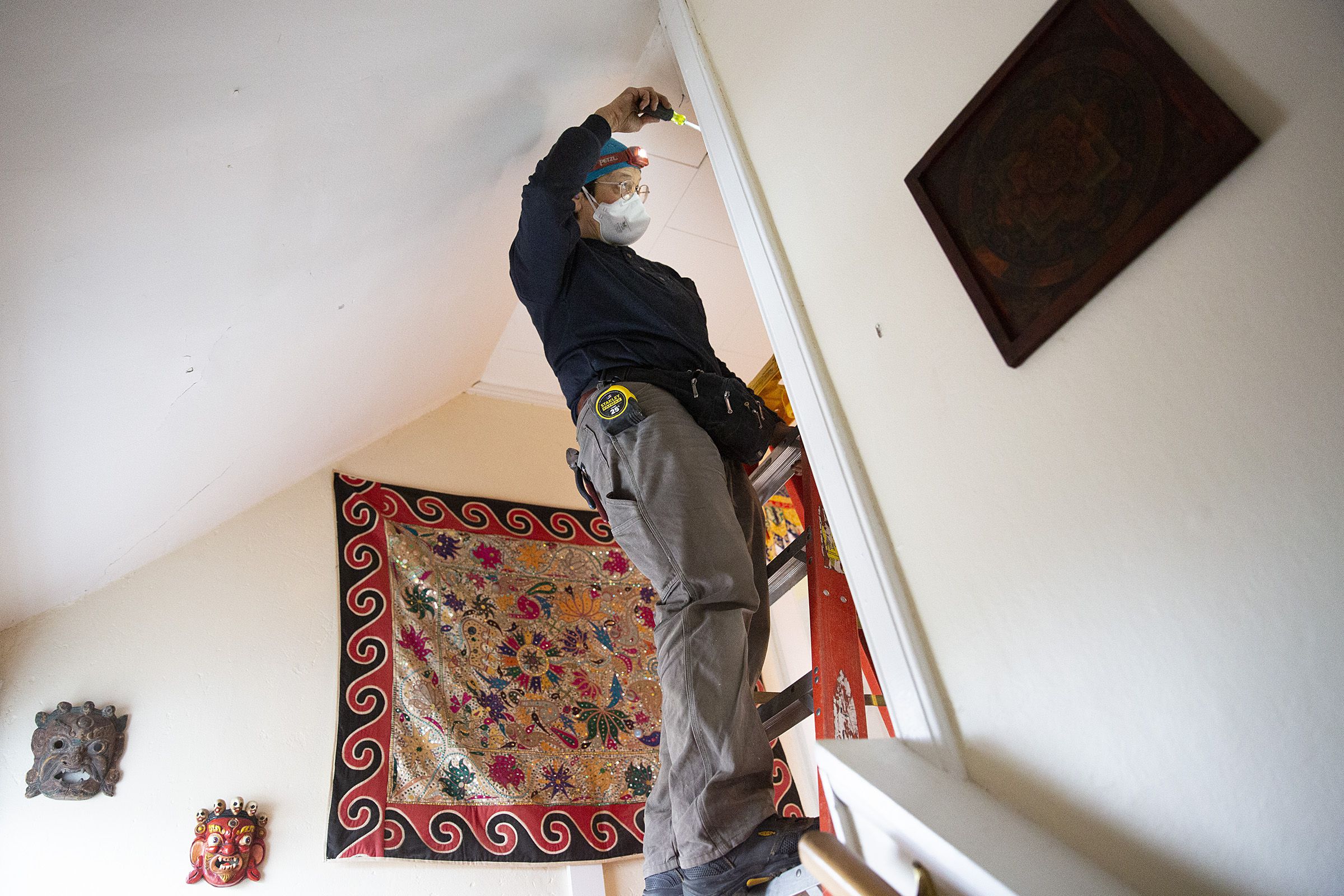 Joanna Sharf, of Cornish, N.H., opens up part of a wall to install an electrical box for a new light fixture at a client’s home in Wilder, Vt., on Thursday, March 24, 2022. Sharf says she wishes that more women would get involved in electrical work, and has volunteered with Vermont Works for Women to help get high school girls interested in the trades. (Valley News / Report For America - Alex Driehaus) Copyright Valley News. May not be reprinted or used online without permission. Send requests to permission@vnews.com.