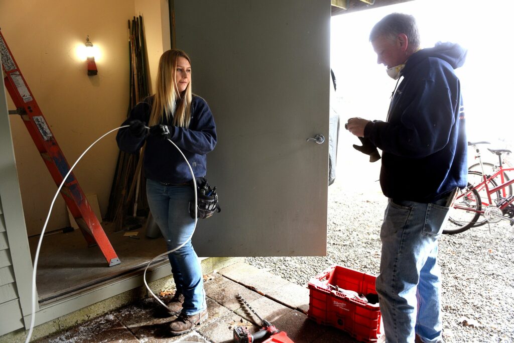 Apprentice electrician Olivia Newcity and master electrician Mike Tenney of Richard Electric work on a job in Quechee, Vt., on Tuesday, March 29, 2022. (Valley News - Jennifer Hauck) Copyright Valley News. May not be reprinted or used online without permission. Send requests to permission@vnews.com.