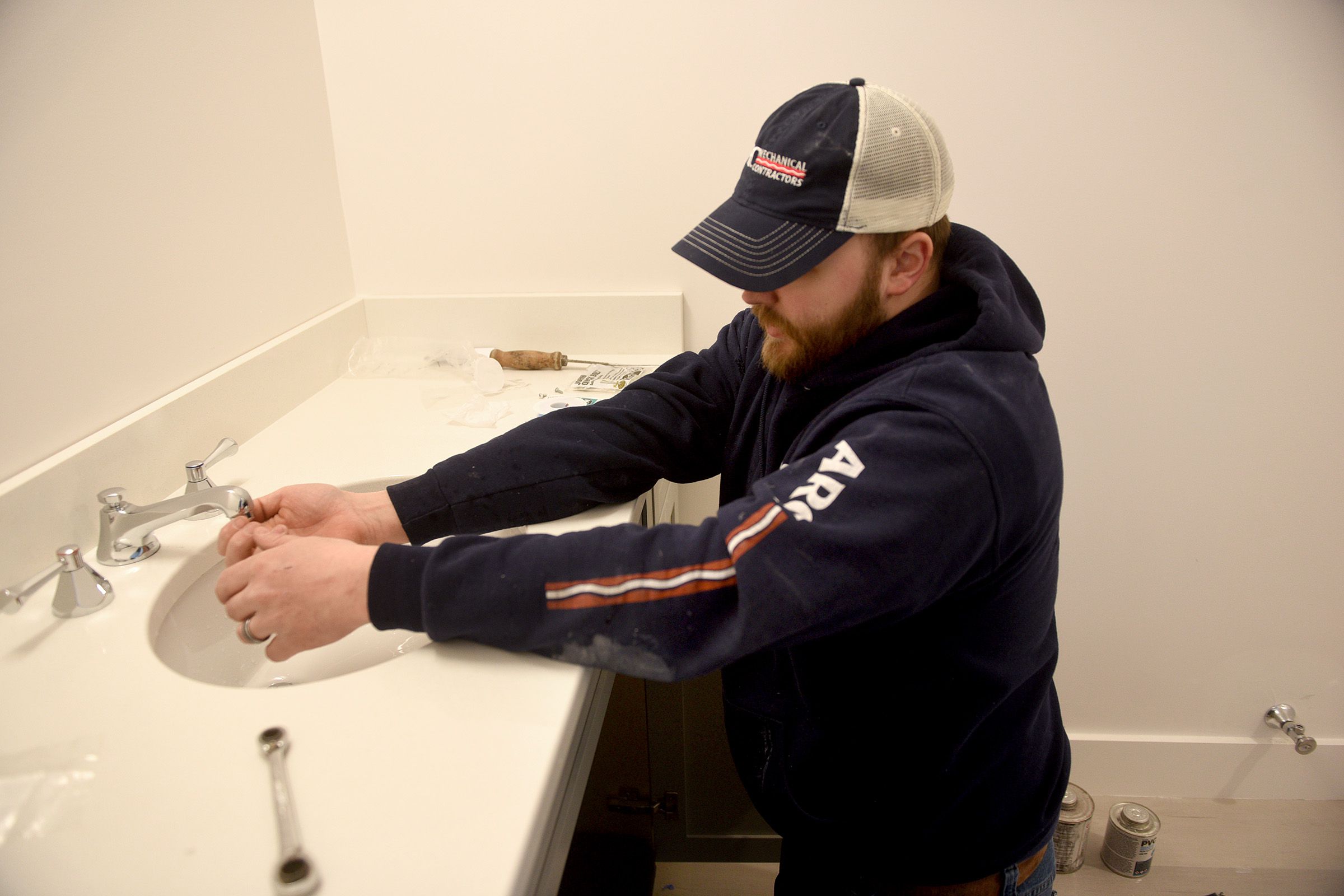 Marc Tetreault checks the water flow of a new bathroom at a job in Lebanon, N.H. on Wednesday, March 30, 2022. Tetreault is in his third year as a plumbing apprentice at ARC Mechanical Contractors. (Valley News - Jennifer Hauck) Copyright Valley News. May not be reprinted or used online without permission. Send requests to permission@vnews.com.