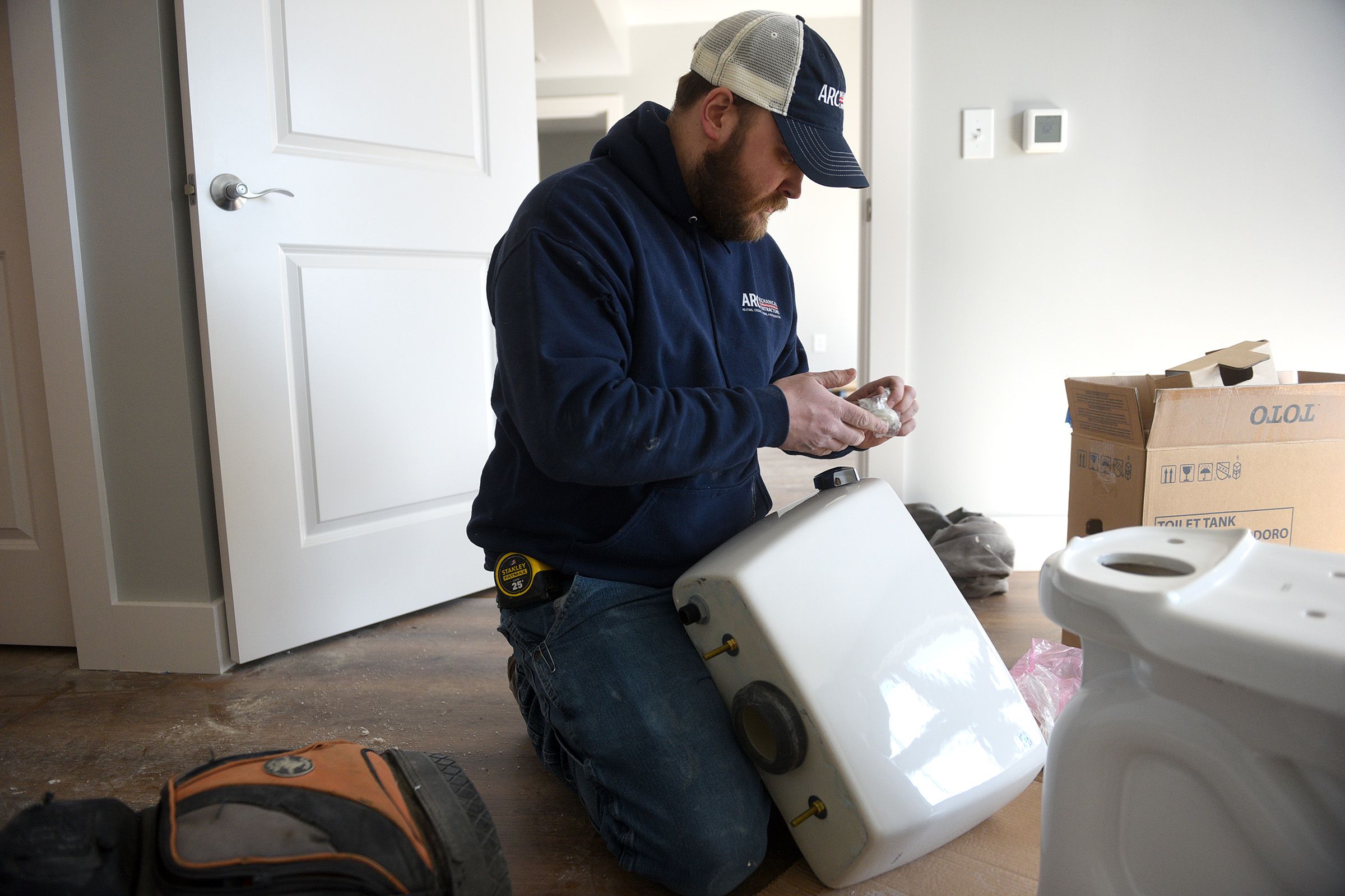 Marc Tetreault works on installing a toilet in Lebanon, N.H. on Wednesday, March 30, 2022. Tetreault is a third year plumbing apprentice at ARC Mechanical Contractors. (Valley News - Jennifer Hauck) Copyright Valley News. May not be reprinted or used online without permission. Send requests to permission@vnews.com.