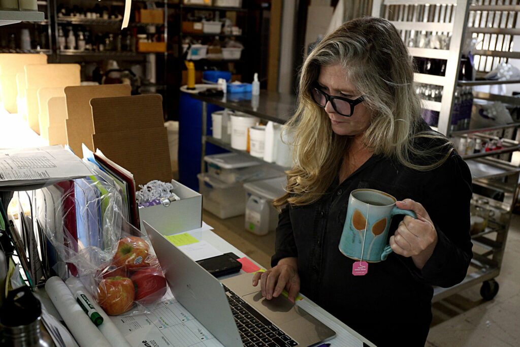 Flourish Beauty Lab owner Kirsten Connor checks emails from customers while working in the shipping area of the White River Junction, Vt., store on June 23, 2002. The business caters to those with sensitive skin. (Valley News - Geoff Hansen) Copyright Valley News. May not be reprinted or used online without permission. Send requests to permission@vnews.com.