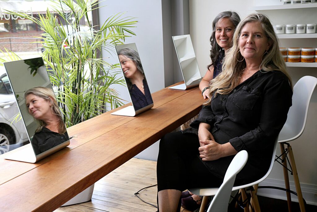 Flourish Beauty Lab owner Kirsten Connor, of Woodstock, Vt., right, and Becky Morlock, of Norwich, Vt., who is the herbalist and relationship specialist at Flourish, work together at the downtown White River Junction, Vt., location to help customers online and in person on June 23, 2022. (Valley News - Geoff Hansen) Copyright Valley News. May not be reprinted or used online without permission. Send requests to permission@vnews.com.